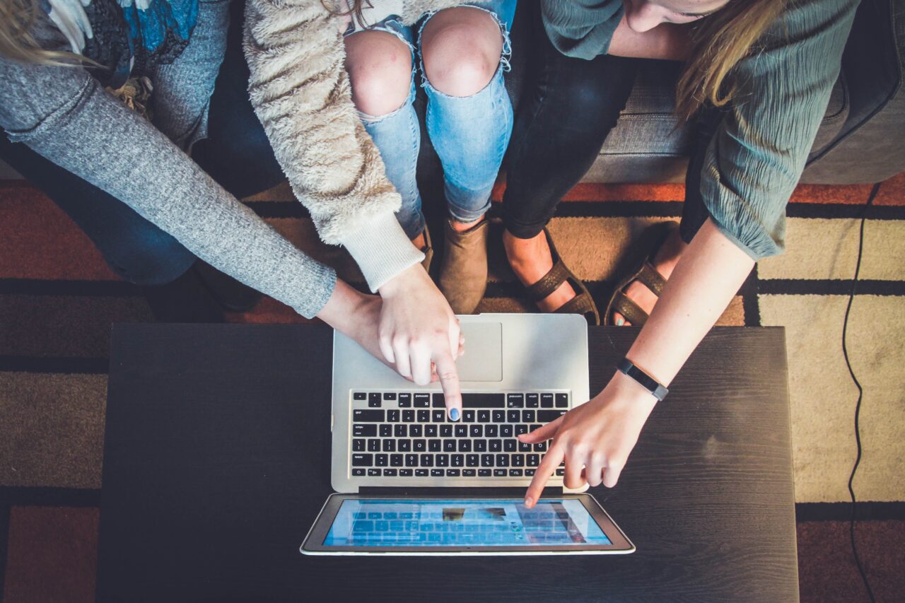 a group of people pointing on a dot on their computer indicating good employee experience