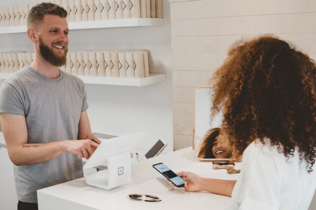 A cashier conducts a survey in the store to close the customer feedback loop.