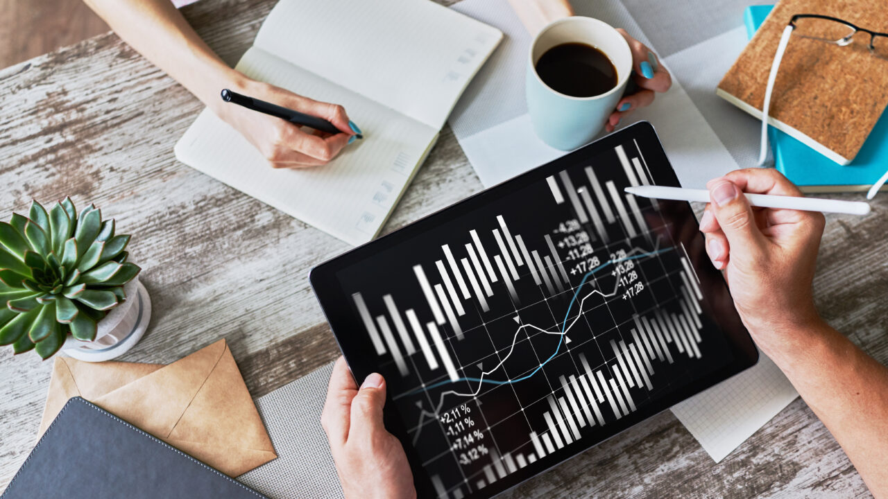 The photo shows a desk where two people work on gathering customer data.