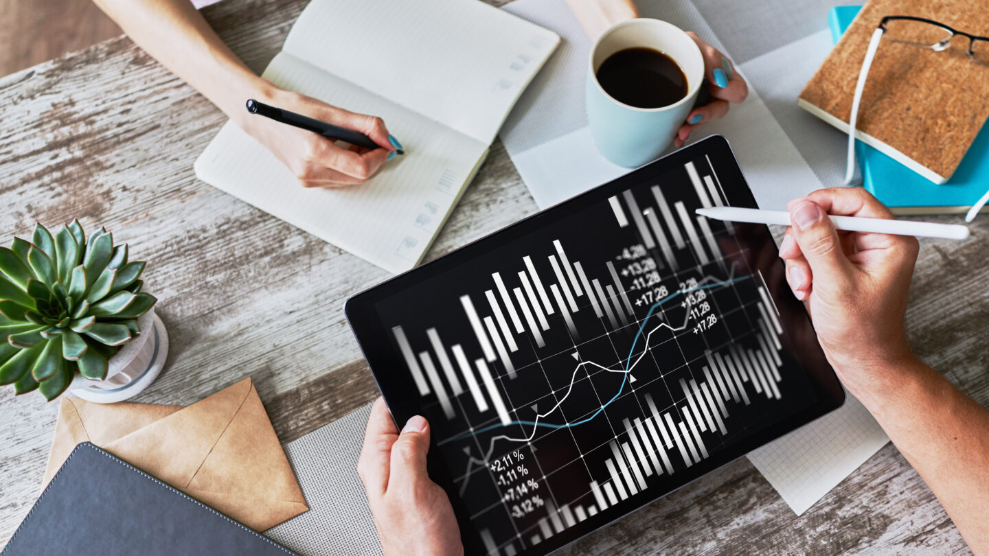 The photo shows a desk where two people work on gathering customer data.
