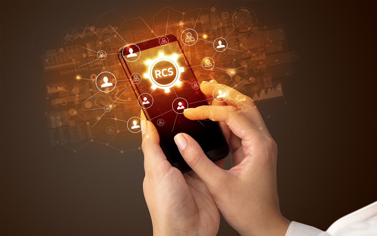 Person using phone showing RCS messaging.