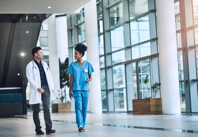 Two healthcare workers walking and talking.