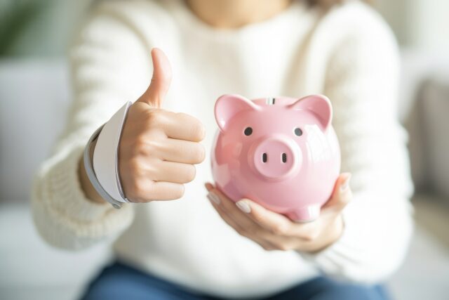 Woman holding a piggy bank to show financial stability.