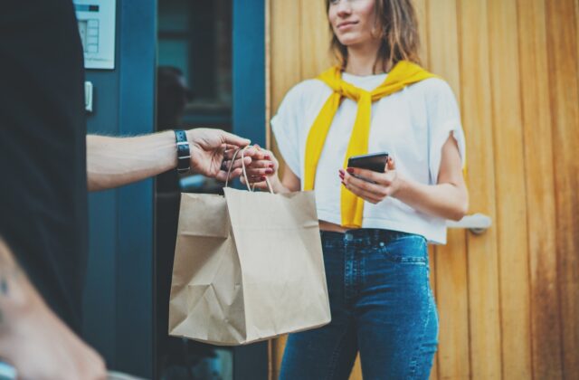Food delivery man is giving food to a woman.