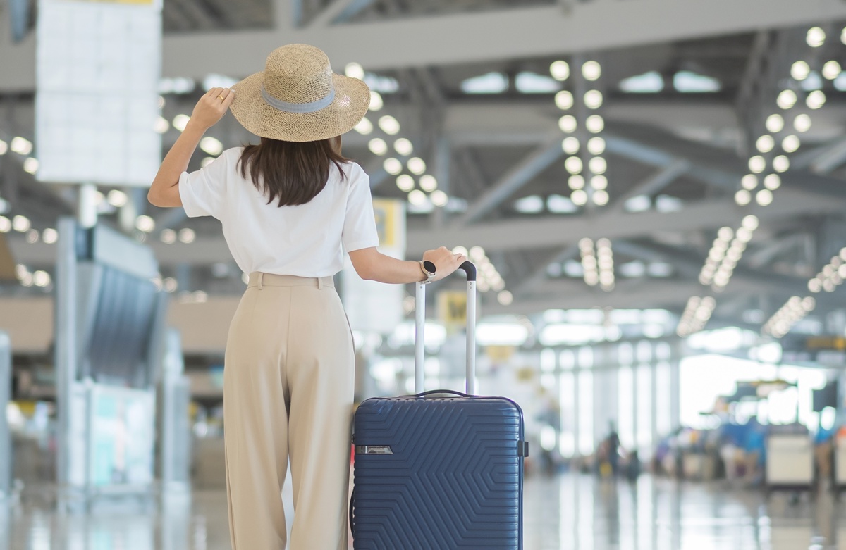 Woman at the airport carrying her suitcase, ready to travel.