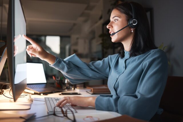 Woman working behind a desk at a contact center.